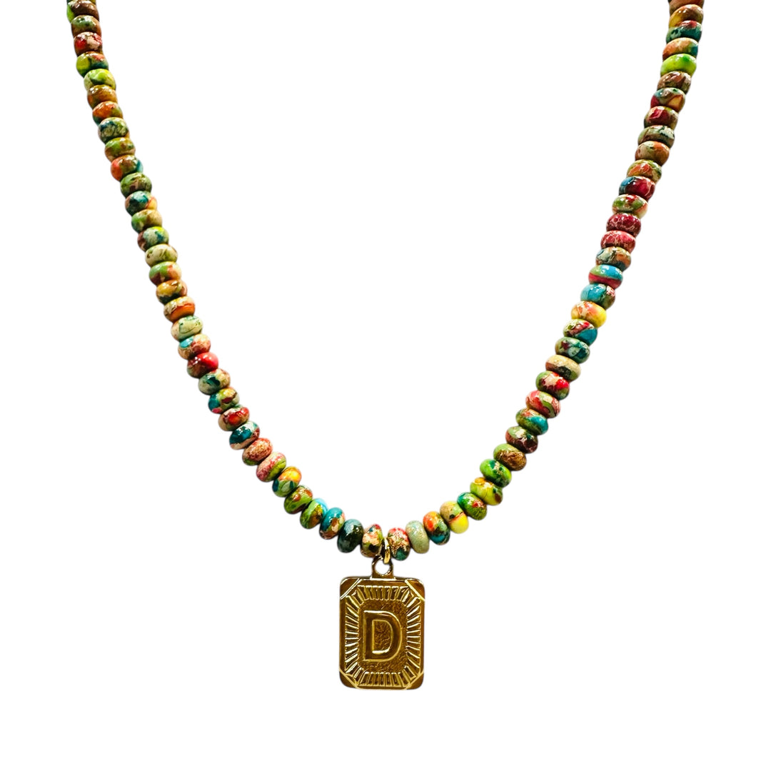 Necklace with multicolored beads and a gold initial pendant on a white background