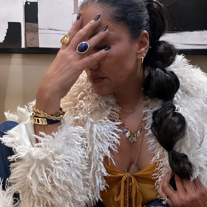 Woman with braided hair wearing gold charm necklace jewelry indoors