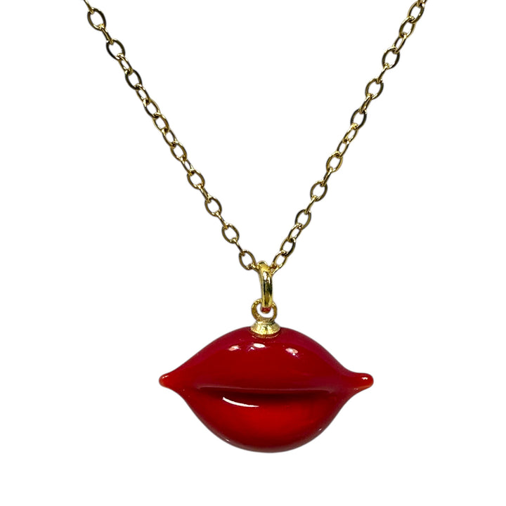Red lip-shaped pendant on a gold chain against a white background