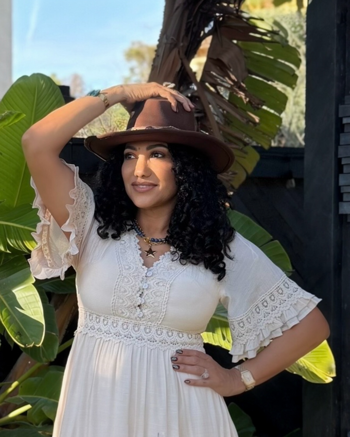 Distressed brown felt western hat with moldable brim and handcrafted beaded hatband styled for boho boutique fashion.