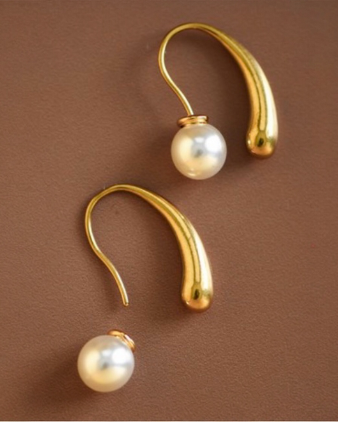 Gold curved pearl drop earrings with stainless steel hooks and round pearl accents.