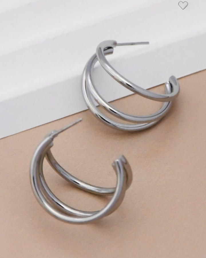 Triple hoop earrings in stainless steel with gold or rhodium plating featuring a layered modern hoop design.