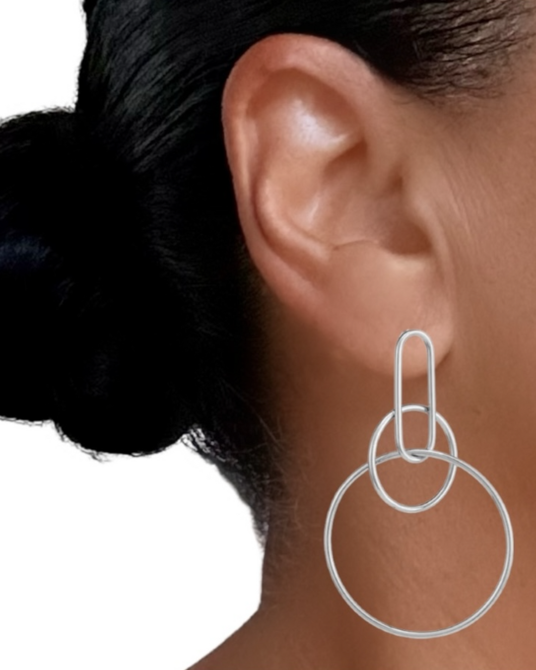 Silver hoop earrings worn by a person with dark hair tied back.