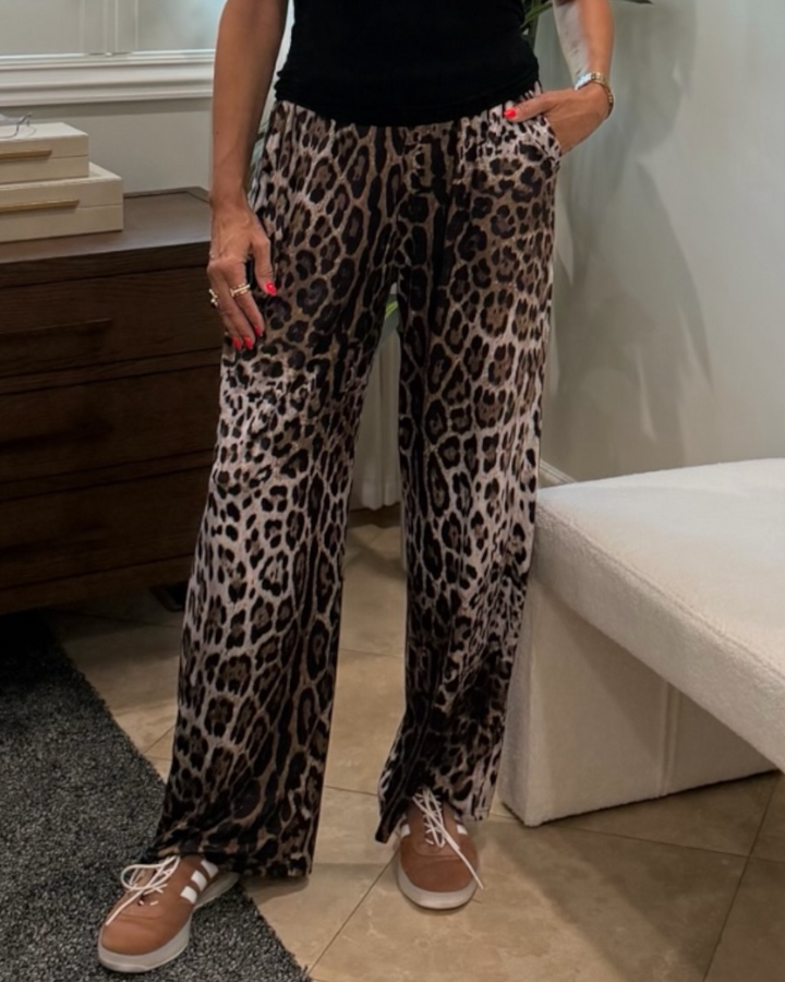 Person wearing leopard print pants in a room setting