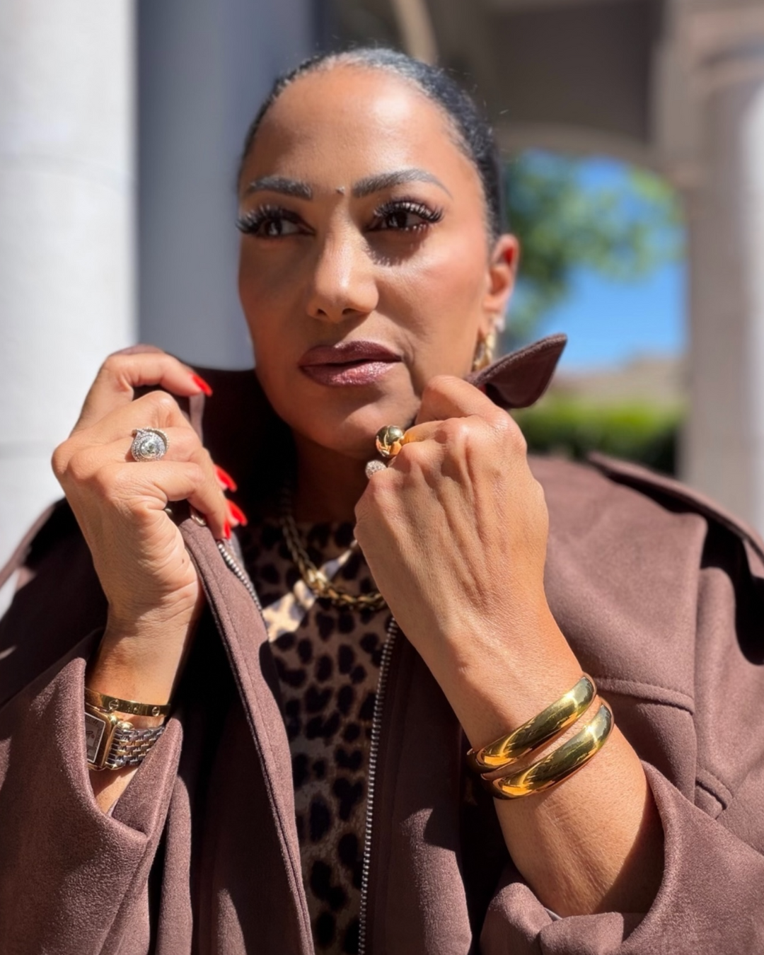Woman wearing a leopard print top and gold bracelet jewelry outdoors