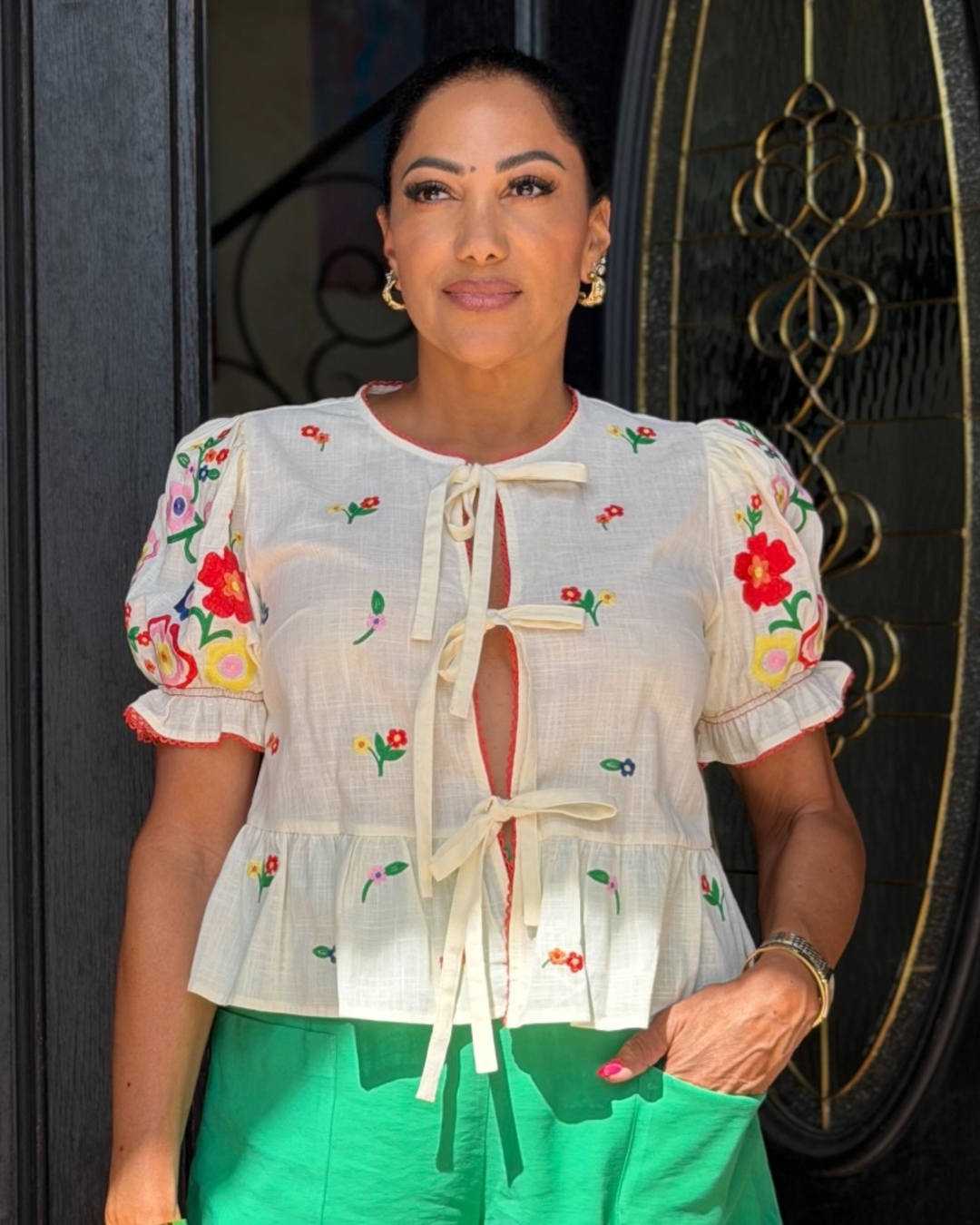 Cream embroidered floral blouse with tie-front detail, puff sleeves, and ruffle hem