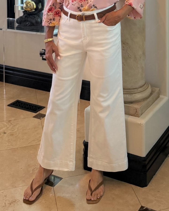 High rise white wide leg jeans with double button closure styled with a floral blouse and brown belt for a polished casual outfit