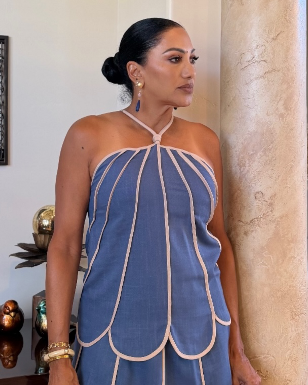 Woman wearing blue scalloped shell panel top, close-up front view
