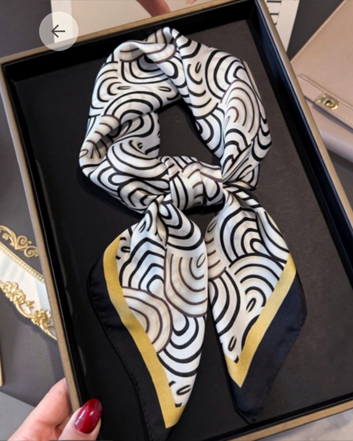 Black white and gold geometric print silk scarf tied on handbag and worn as hair accessory