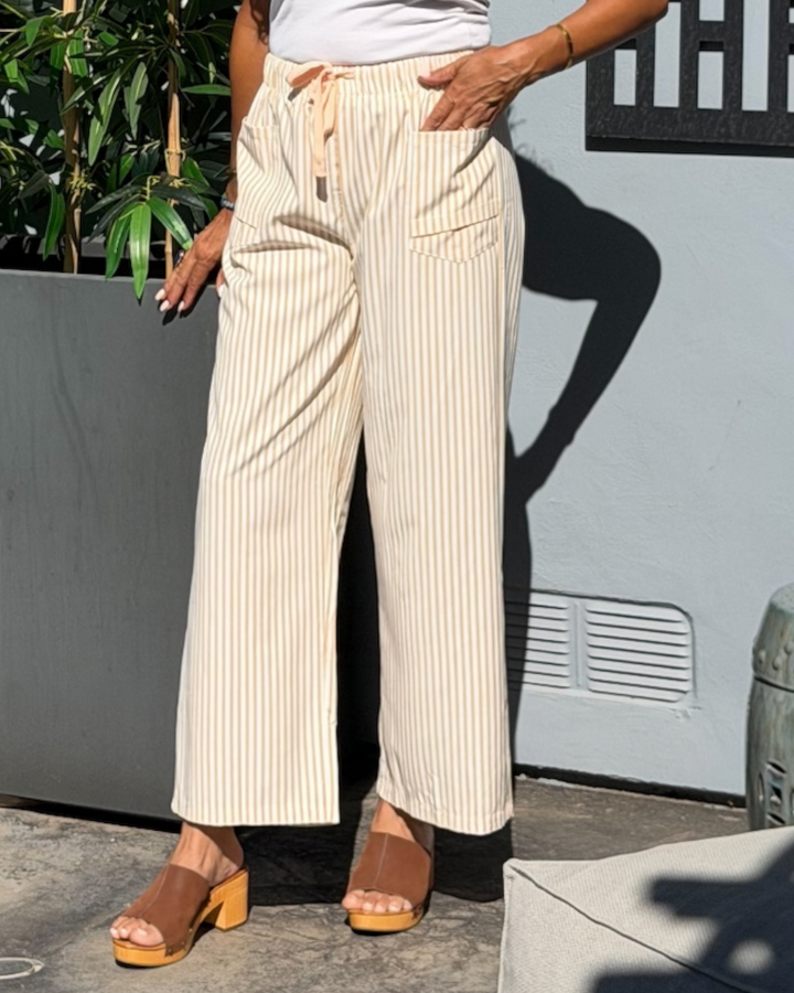 Woman wearing cream and tan striped drawstring wide-leg pants,