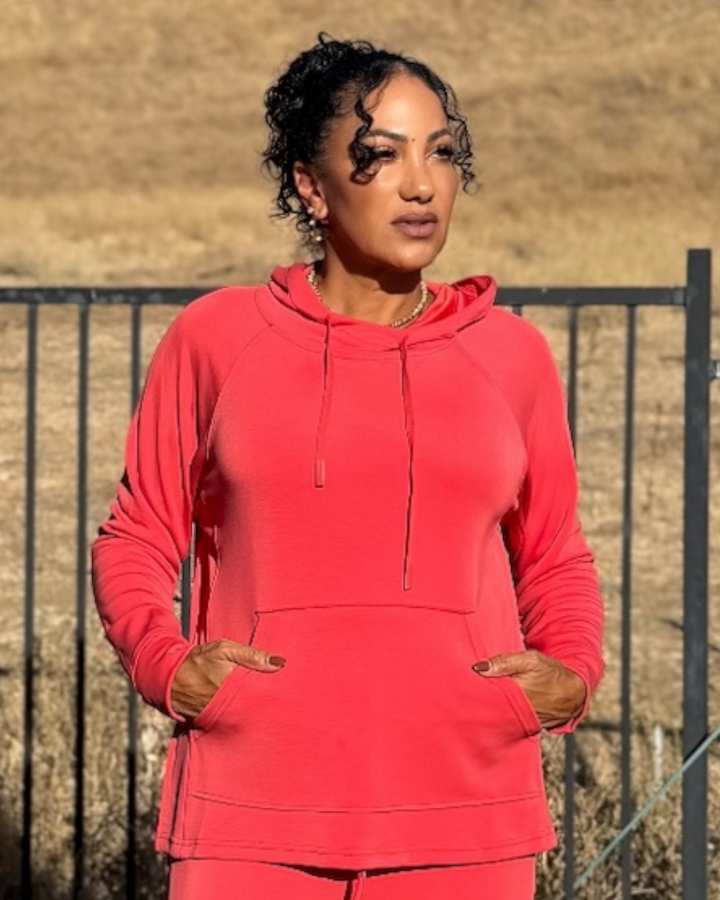 Front view of Mira Blushed Brick hooded pullover with the hood up, drawstring, and kangaroo pocket